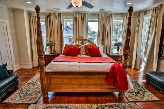 a bedroom with a bed a dresser and flat screen tv