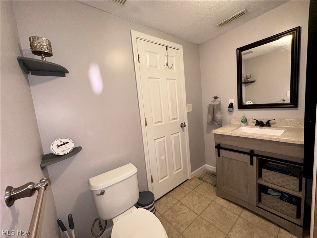 5770 Jaycox Road North Ridgeville, OH 44039 - Photo 19 of 31 Bathroom with light tile flooring, mirror, large vanity, and a textured ceiling