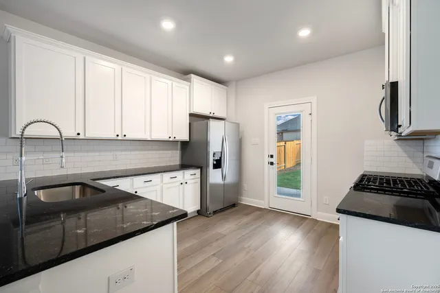 a kitchen with a sink a refrigerator a stove a microwave and cabinets