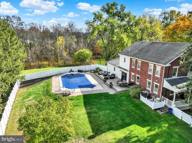 a view of yard with swimming pool and trees in the background