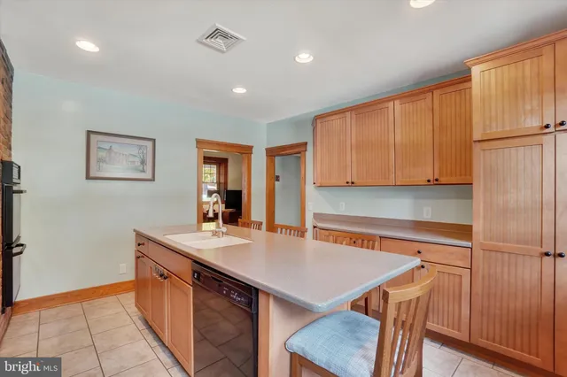 a kitchen with stainless steel appliances granite countertop a sink a microwave refrigerator and chairs