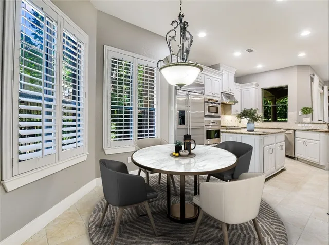 a dining room with furniture a chandelier and window