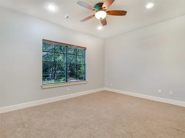 an empty room with a window and a fan