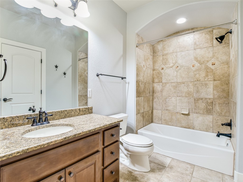 1036 Liberty Park Drive, Unit 54 Austin, TX 78746 - Photo 18 of 24 a bathroom with a granite countertop sink a toilet and bathtub
