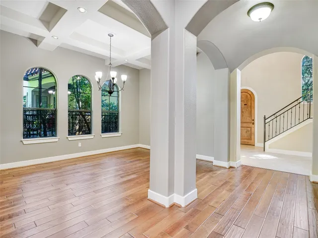 a view of a room with wooden floors and entryway