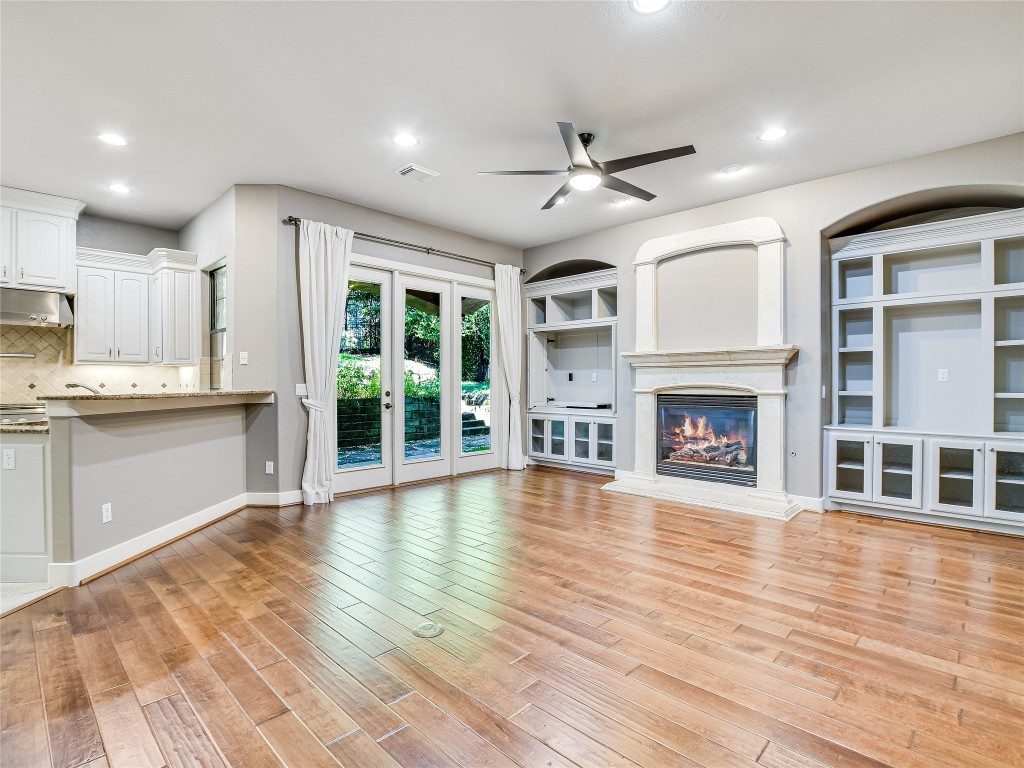 1036 Liberty Park Drive, Unit 54 Austin, TX 78746 - Photo 6 of 24 a view of an empty room with wooden floor and a kitchen