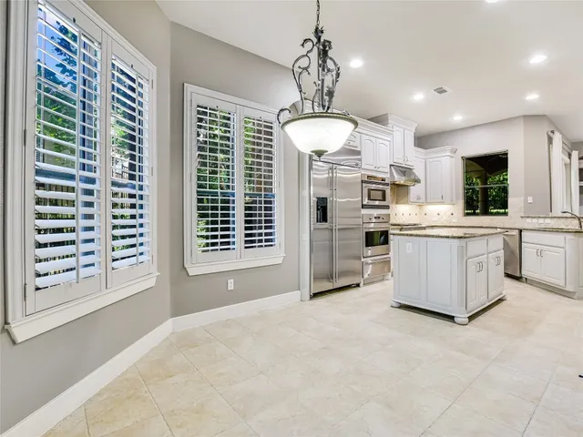a large kitchen with kitchen island a large counter space a sink appliances and cabinets