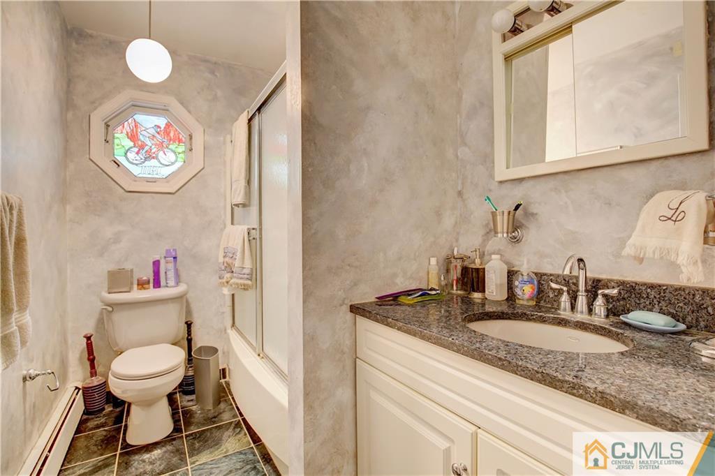 3 Pendleton Place Edison, NJ 08820 - Photo 30 of 47 a bathroom with a granite countertop sink a mirror and a toilet