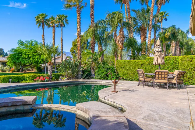 a view of a patio with a table chairs and a garden