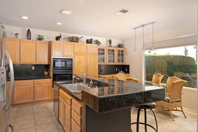 a kitchen with stainless steel appliances granite countertop a sink a stove and a refrigerator