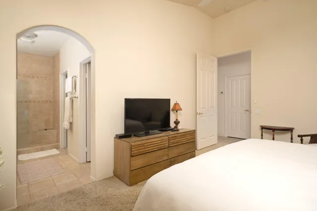 a bedroom with a bed and a flat screen tv