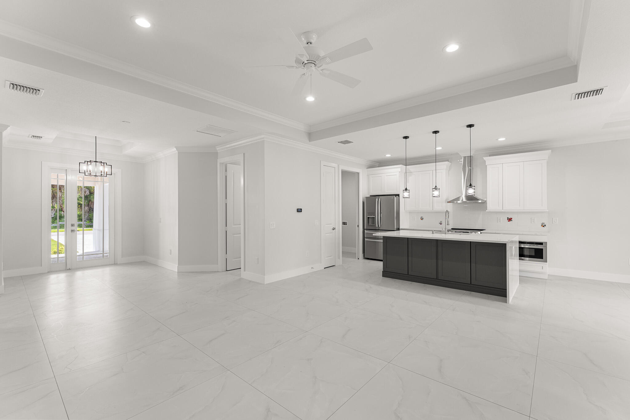 5470 Southeast Front Avenue Stuart, FL 34997 - Photo 14 of 37 a large white kitchen with kitchen island a sink stainless steel appliances and cabinets