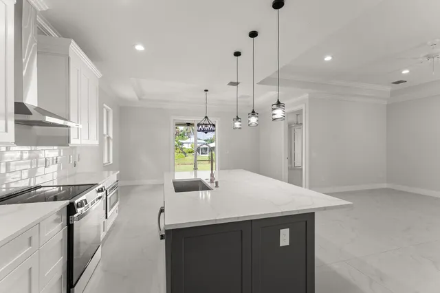 a kitchen with kitchen island a sink appliances and a counter top space