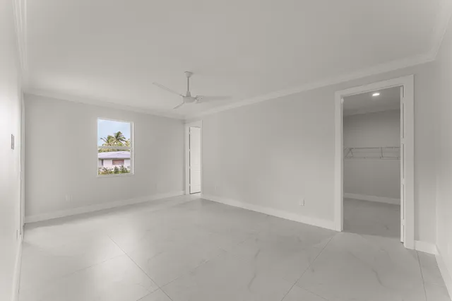 an empty room with windows and cabinet