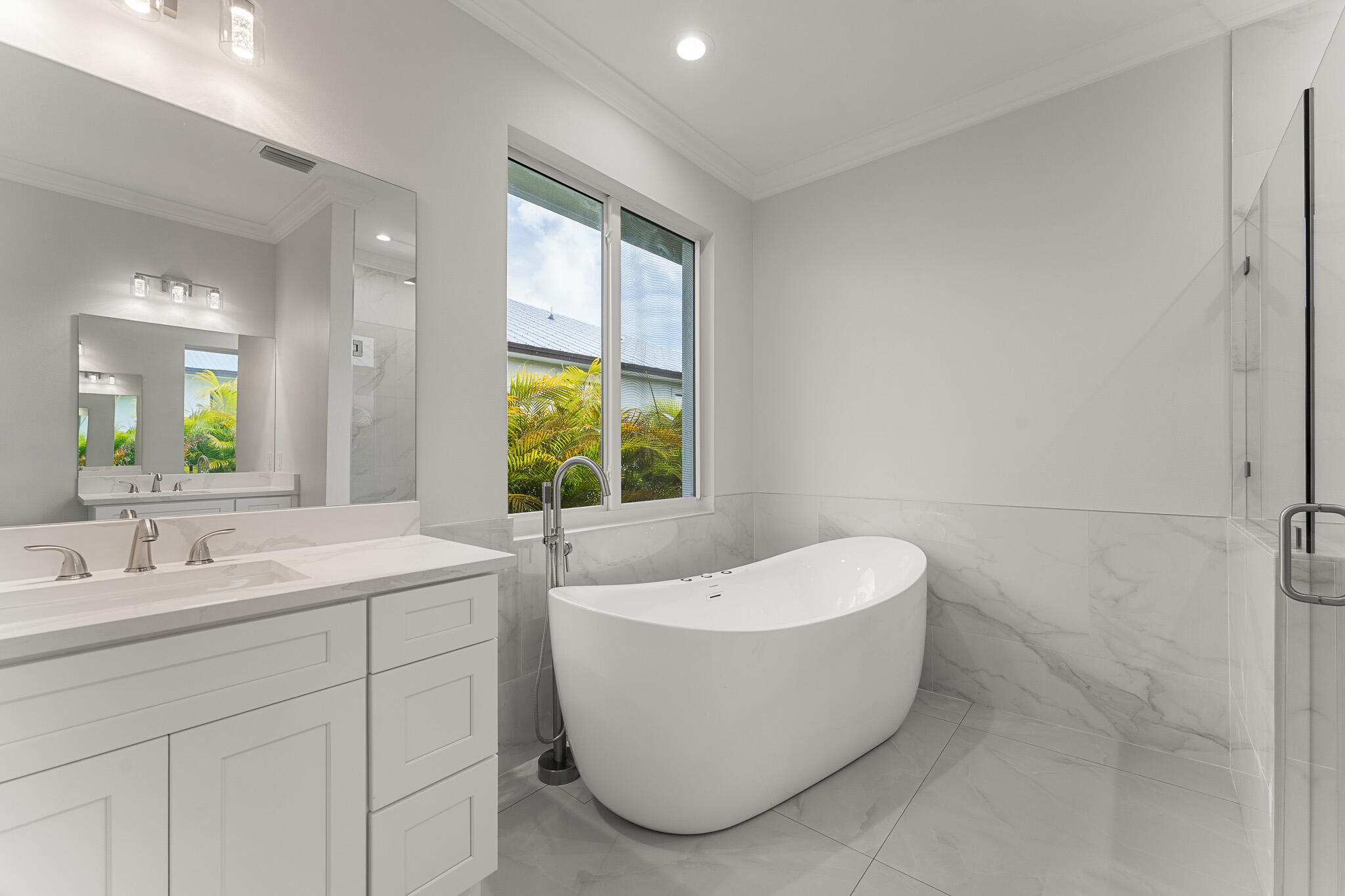 5470 Southeast Front Avenue Stuart, FL 34997 - Photo 23 of 37 a bathroom with a white tub a sink and a window