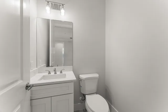 a bathroom with a sink mirror and toilet