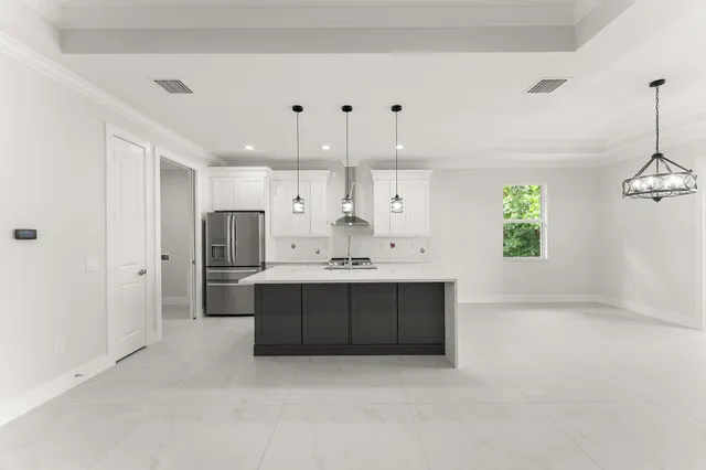 a view of kitchen with stainless steel appliances kitchen island refrigerator stove and microwave