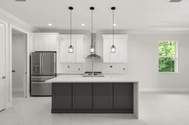 a kitchen with kitchen island a sink a counter space appliances and cabinets