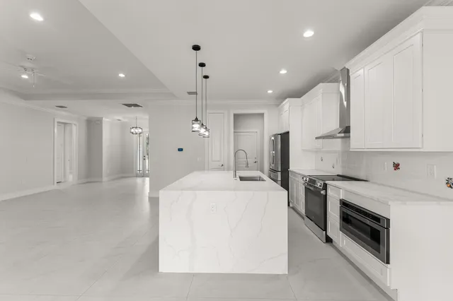 a large white kitchen with a stove a sink and a refrigerator