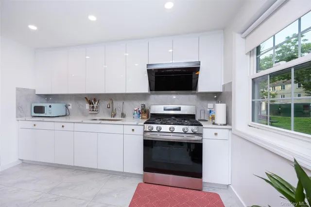 a kitchen with granite countertop a stove top oven sink and cabinets