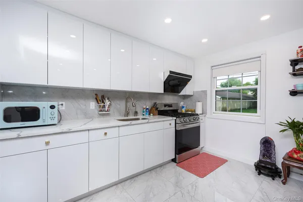 a kitchen with stainless steel appliances kitchen island granite countertop a sink and a stove