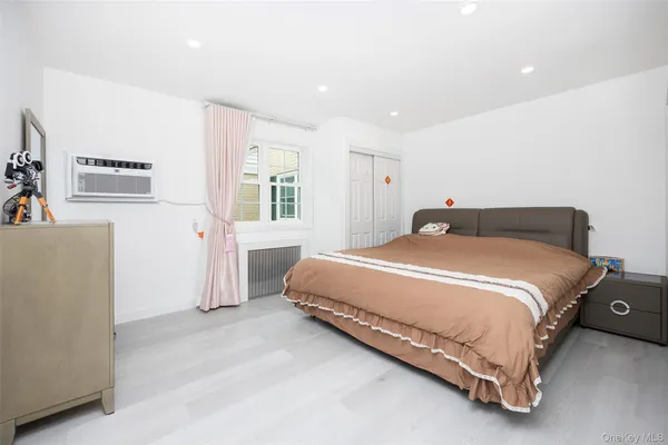 a spacious bedroom with a bed and a cabinets