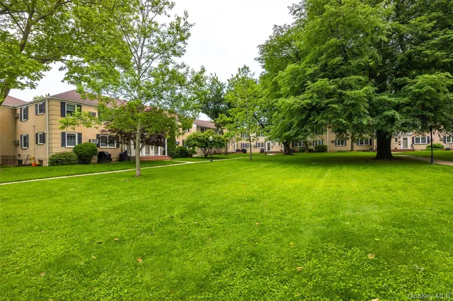 a view of a yard with a house and large trees