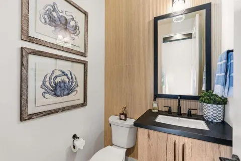 a bathroom with a granite countertop sink mirror vanity and toilet