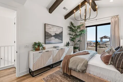 a bedroom with a bed a dresser next to a window