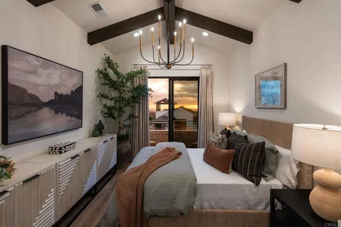 a bedroom with bed tv and window