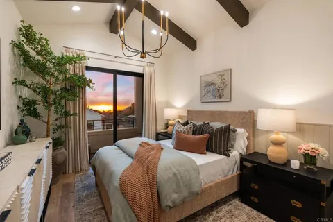 a bedroom with a bed a chandelier and a window