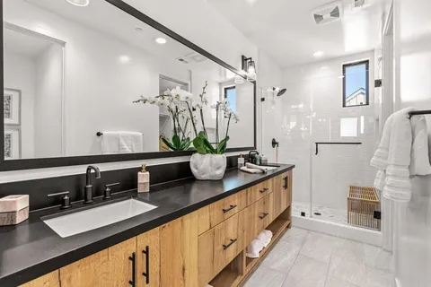 a bathroom with double vanity and a mirror