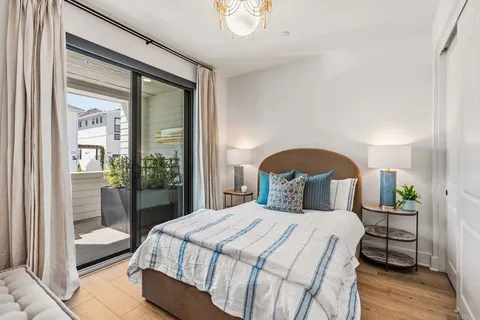 a bedroom with a bed mirror and a window