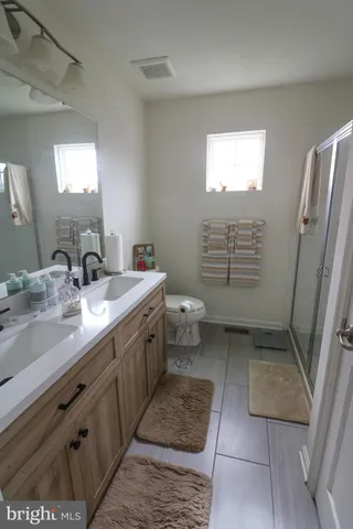a bathroom with a sink a toilet and shower
