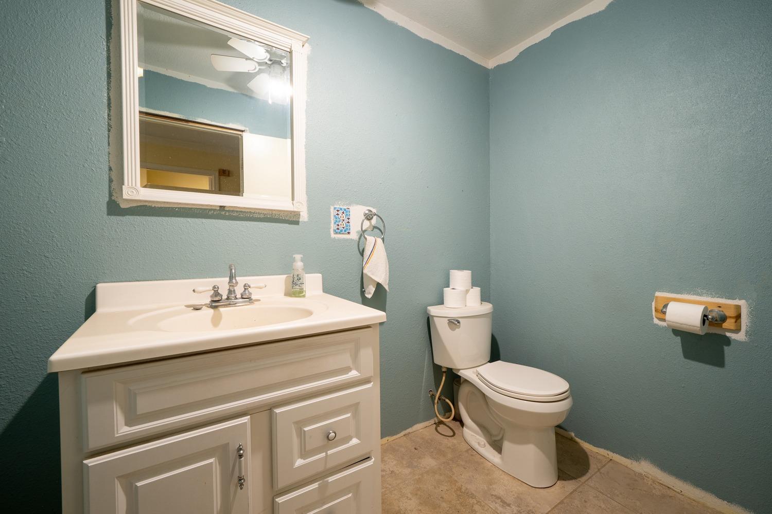 26166 Eddy Way Madera, CA 93638 - Photo 17 of 25 a bathroom with a toilet sink and mirror