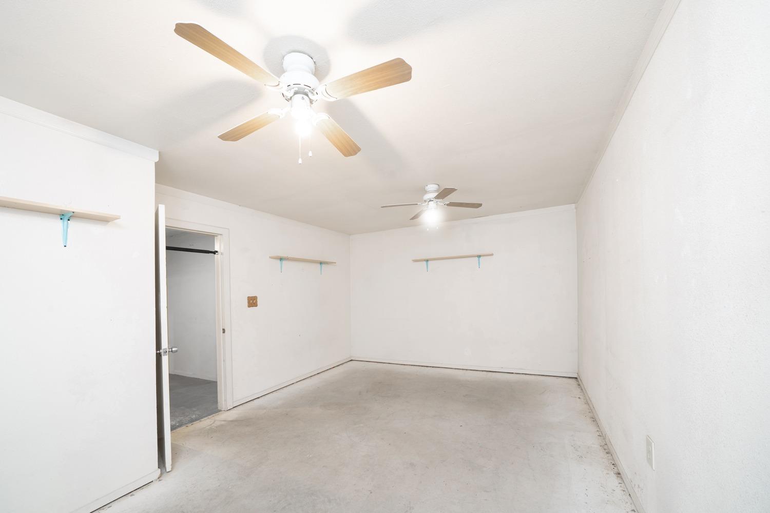 26166 Eddy Way Madera, CA 93638 - Photo 18 of 25 an empty room with a ceiling fan and a window