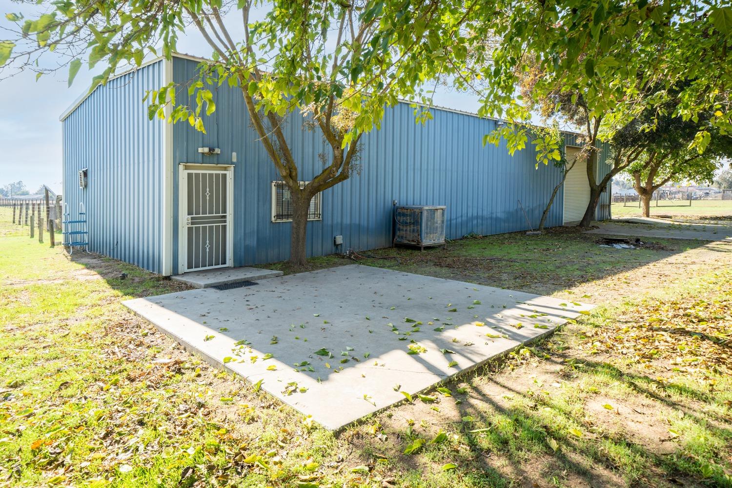 26166 Eddy Way Madera, CA 93638 - Photo 9 of 25 a backyard of a house with large trees and wooden fence
