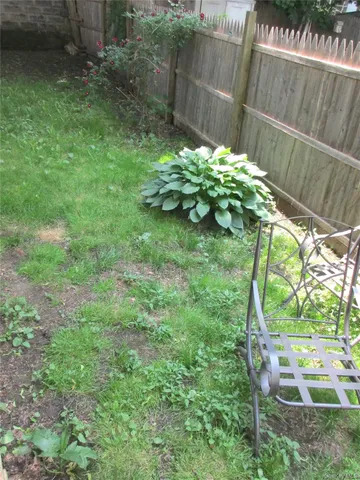a backyard of a house with large trees and plants