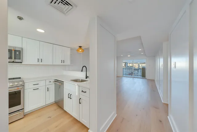 a view of a livingroom with a kitchen counter tops and a wooden floor