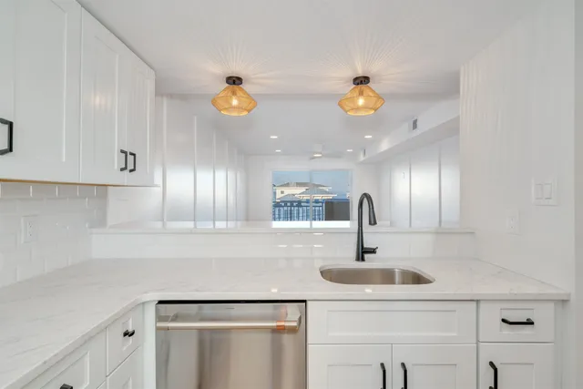 a view of a kitchen with a sink and a refrigerator
