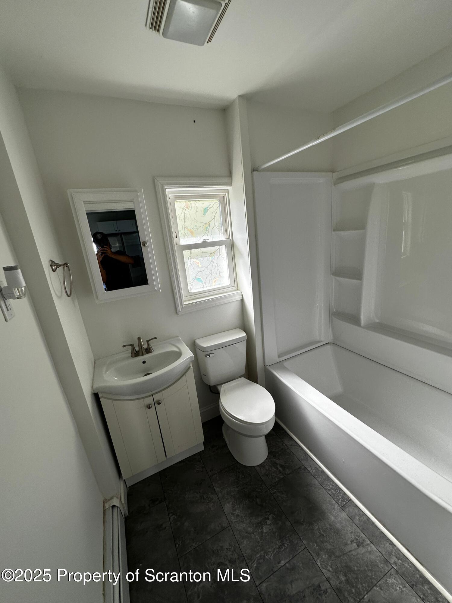 1417 Cornell Street, Unit 2 Scranton, PA 18504 - Photo 11 of 11 a bathroom with a toilet a sink a window and mirror