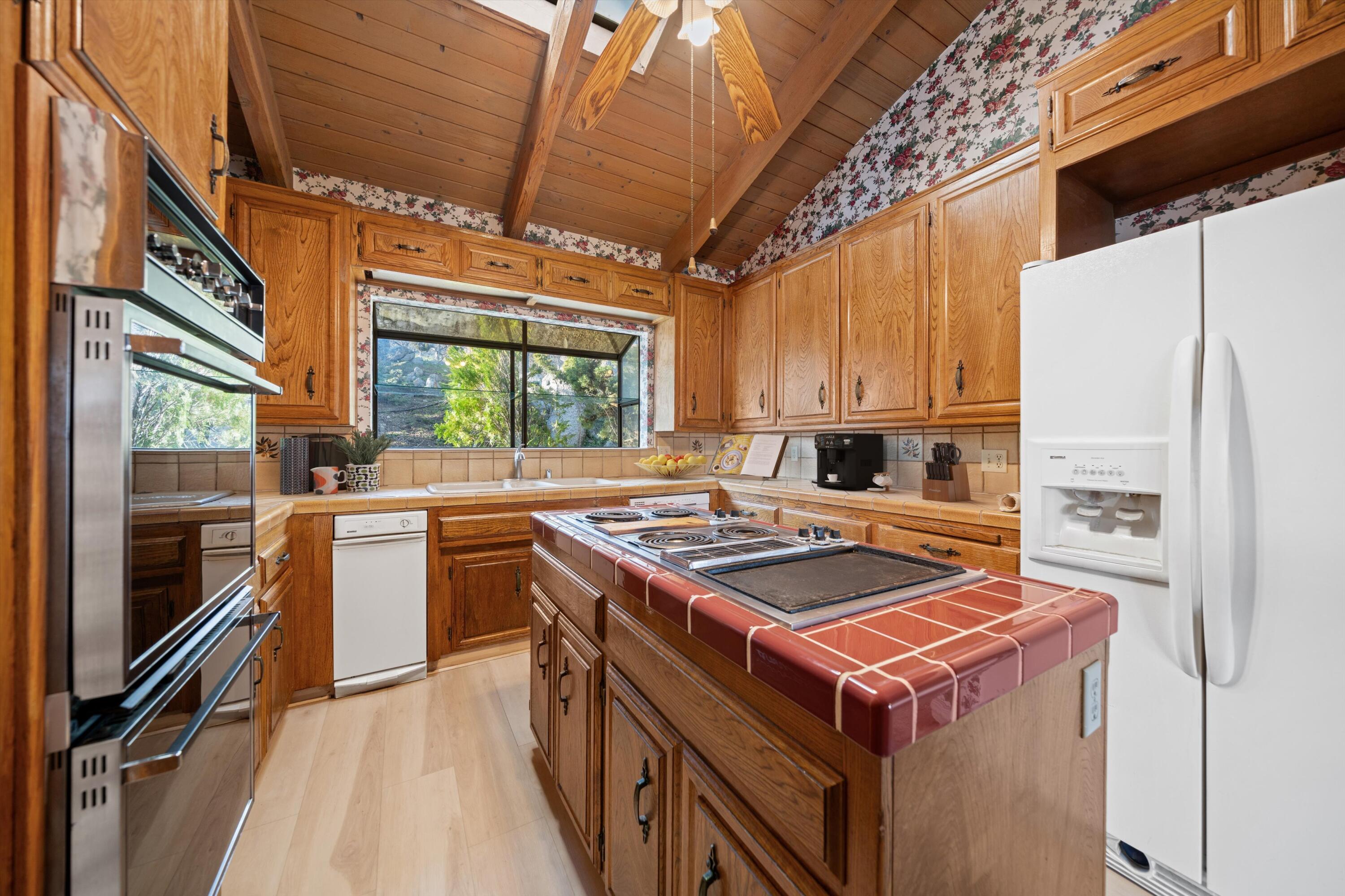 24701 Deertrail Drive Tehachapi, CA 93561 - Photo 5 of 24 a kitchen with a stove a sink and a refrigerator