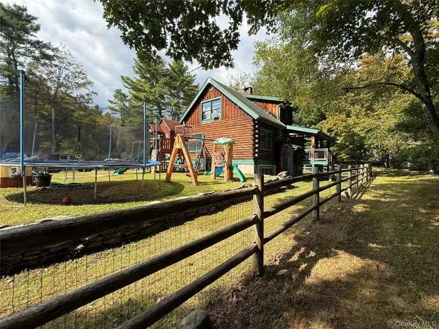 a view of a house with a yard balcony and tree