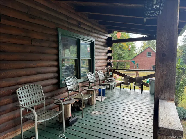 a view of a patio with table and chairs with wooden floor and floor to ceiling window