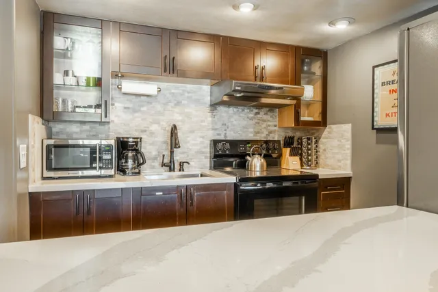 a kitchen with stainless steel appliances granite countertop a stove and a refrigerator
