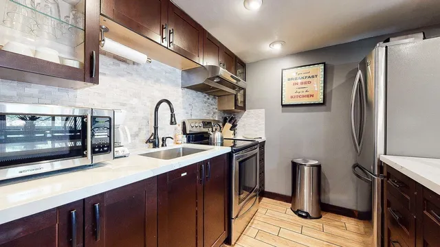 a kitchen with stainless steel appliances a sink stove and refrigerator