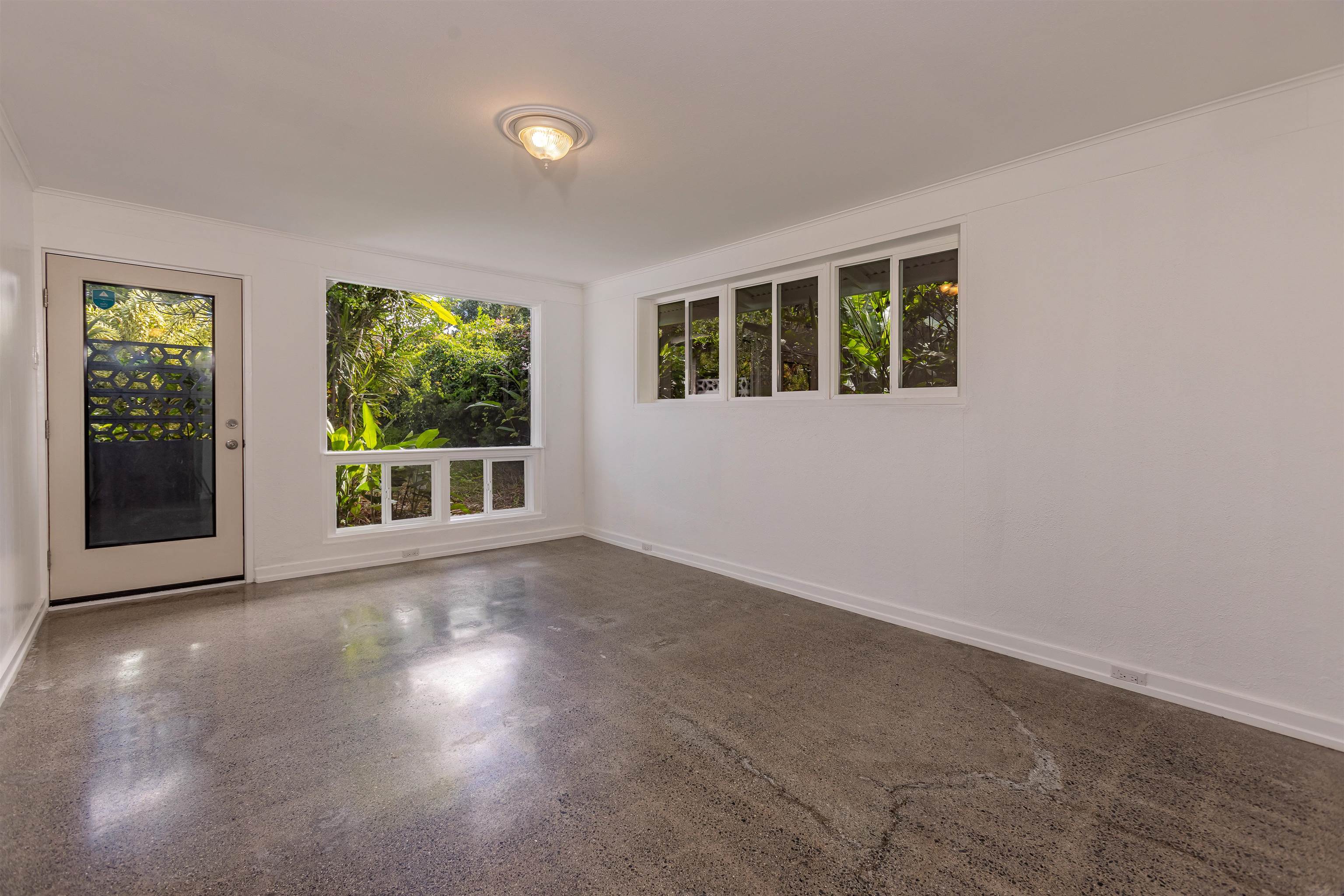 720 Mopua Street Haiku, HI 96708 - Photo 5 of 20 a view of an empty room with wooden floor and a window