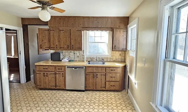 a kitchen with a refrigerator sink and cabinets