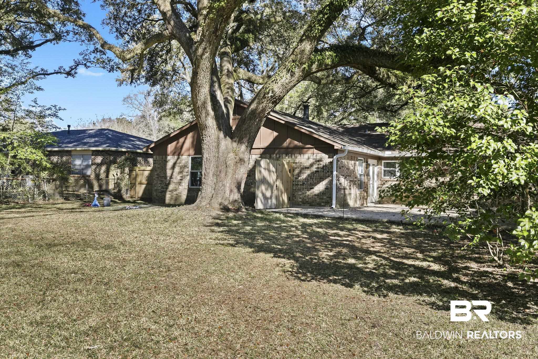 5817 Woodgate Road Mobile, AL 36609 - Photo 71 of 85 Back of property with a lawn and brick siding
