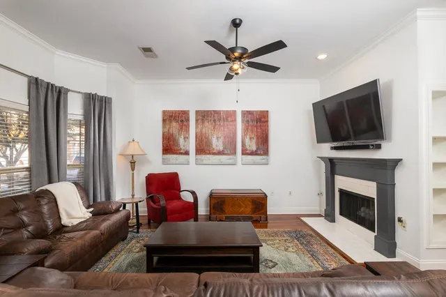 a living room with furniture a flat screen tv and a fireplace